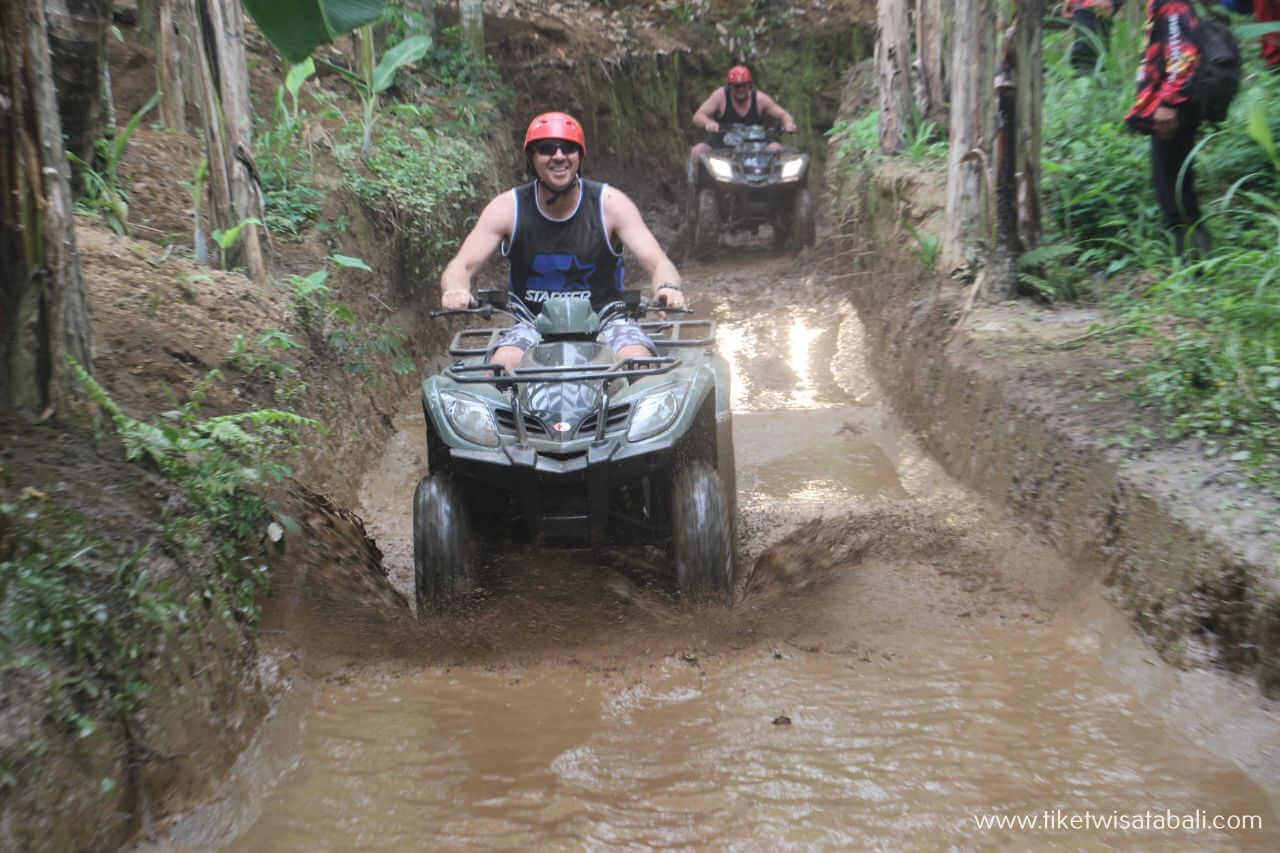 ATV quad bike riding through a muddy track in Ubud, Bali