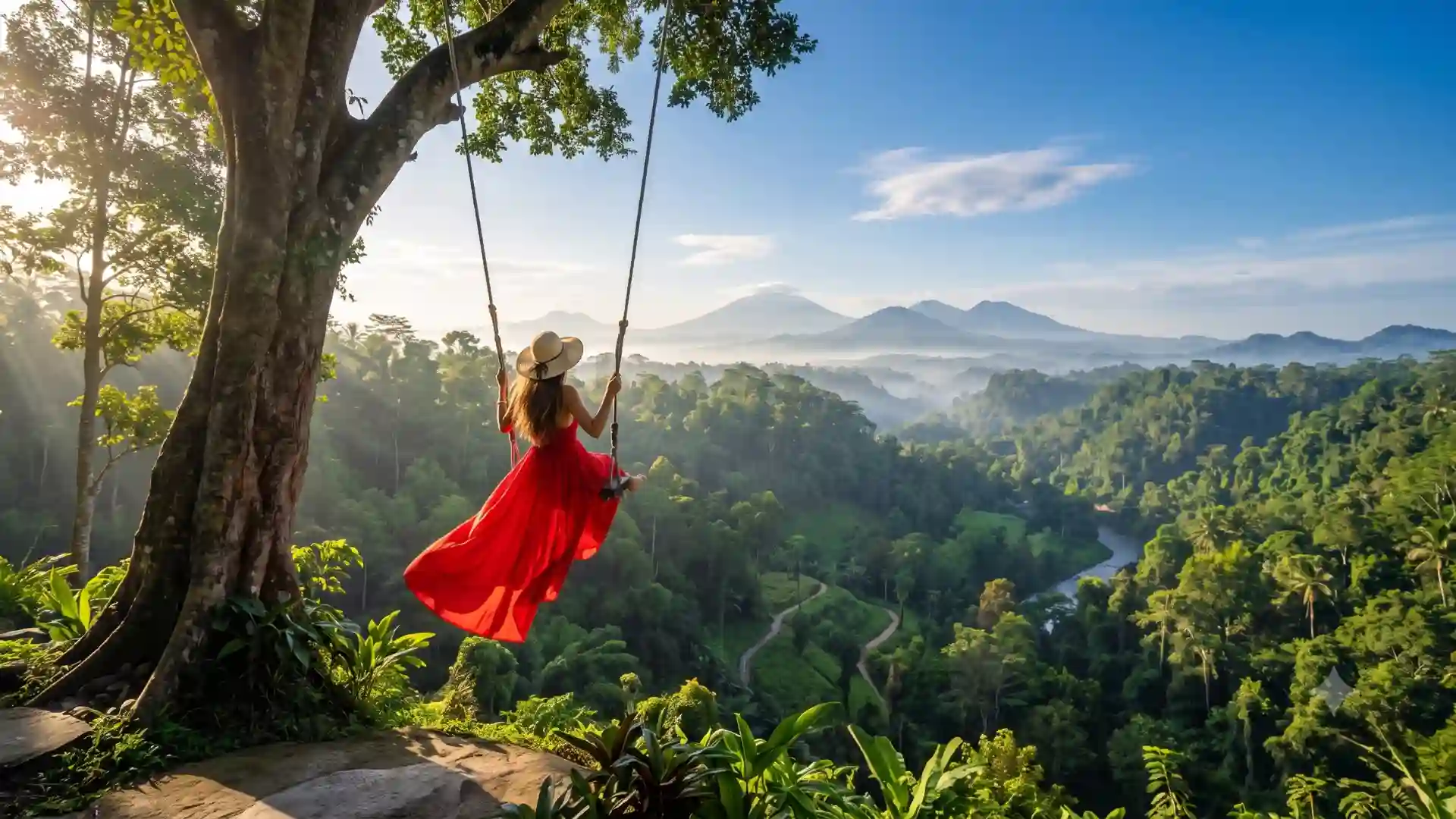 Woman in a red dress on a swing above the jungle in Bali