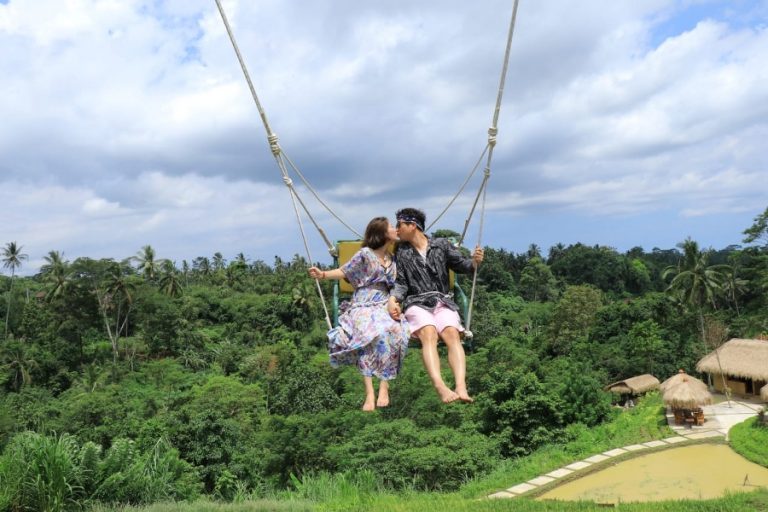 Couple on a swing above a jungle valley in Ubud, Bali
