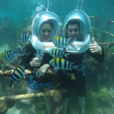 Two people ocean walking underwater with fish at Tanjung Benoa, Bali