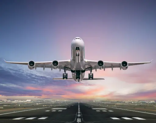 Airplane landing on a runway at sunset