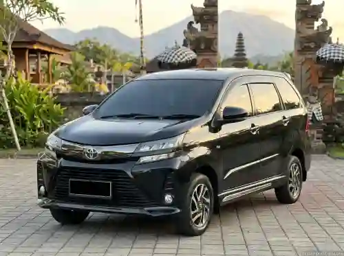 Black Toyota Avanza private car in front of a Balinese gate